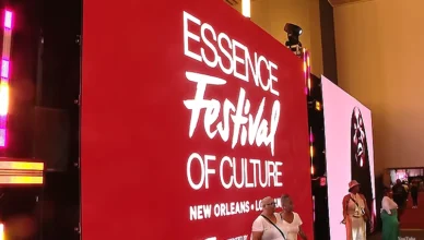 Essence Festival 2025 attendees take pictures in front of a sign. (Credit: YouTube/WWL)