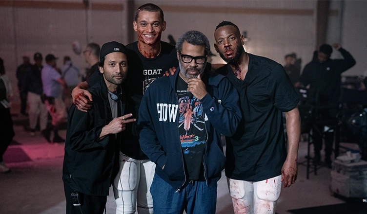 L to R: Director Justin Tipping, Tyriq Withers (as Cam), Producer Jordan Peele, and Marlon Wayans (as Isaiah) on the set of HIM (Credit: Universal Pictures)