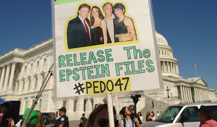 WASHINGTON, DC - September 3, 2025: A protester at the U.S. Capitol holds a sign showing Donald Trump and Melania Trump with Jeffrey Epstein. (Credit: Shutterstock)