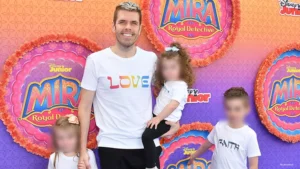 Perez Hilton is shown with his three children at a Disney red carpet event. The children's faces have been blurred. (Credit: Shutterstock)