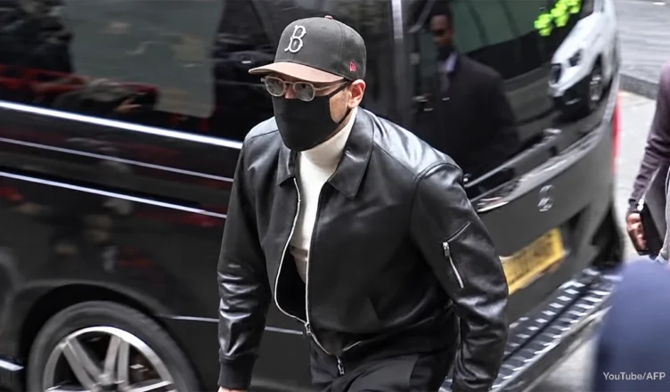 Chris Brown arrived at court in London dressed casually for the hearing in a black leather jacket, with a white turtleneck, black slacks, a baseball cap, a black face mask and dark shades on Monday, October 26, 2026. (Credit: Screengrab from YouTube/AFP)